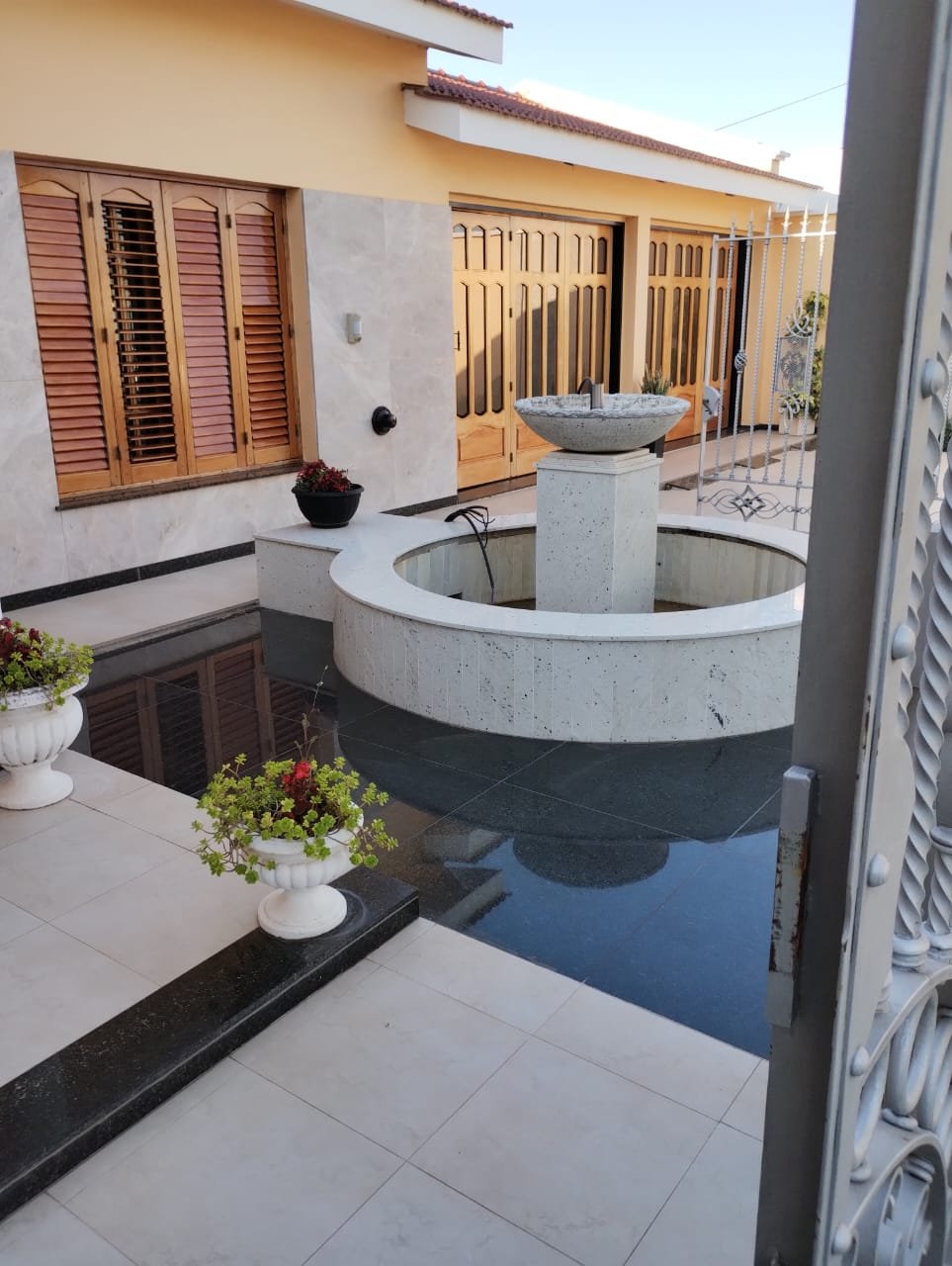Fuente de agua revestida en granito negro en patio