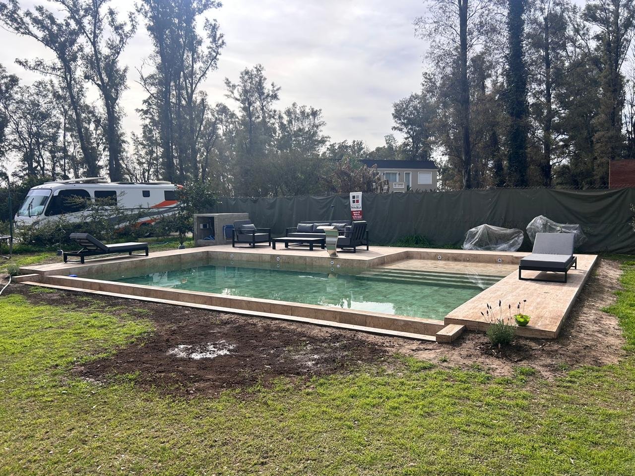 Piscina en construcción revestida en piedra travertino